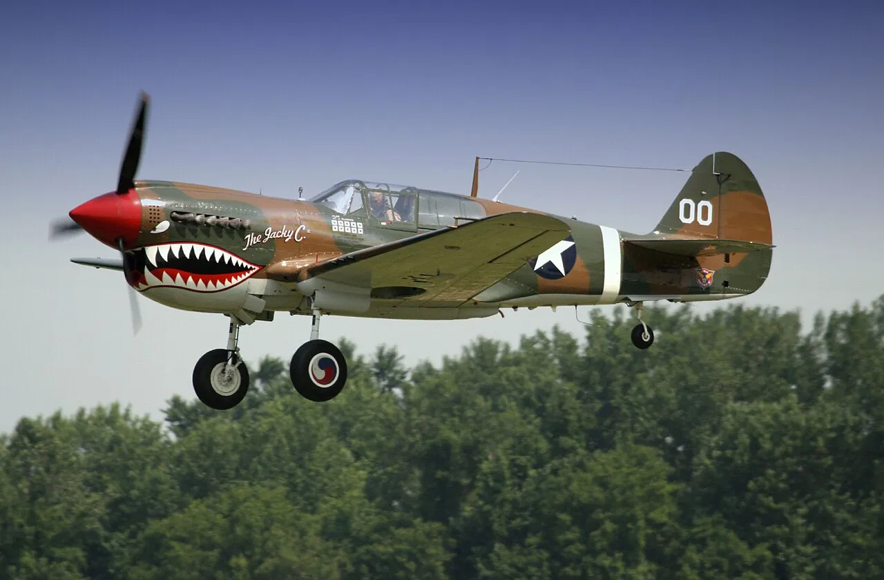 A camouflaged Curtiss P-40 Warhawk fighter on display at the Geneseo Airshow.