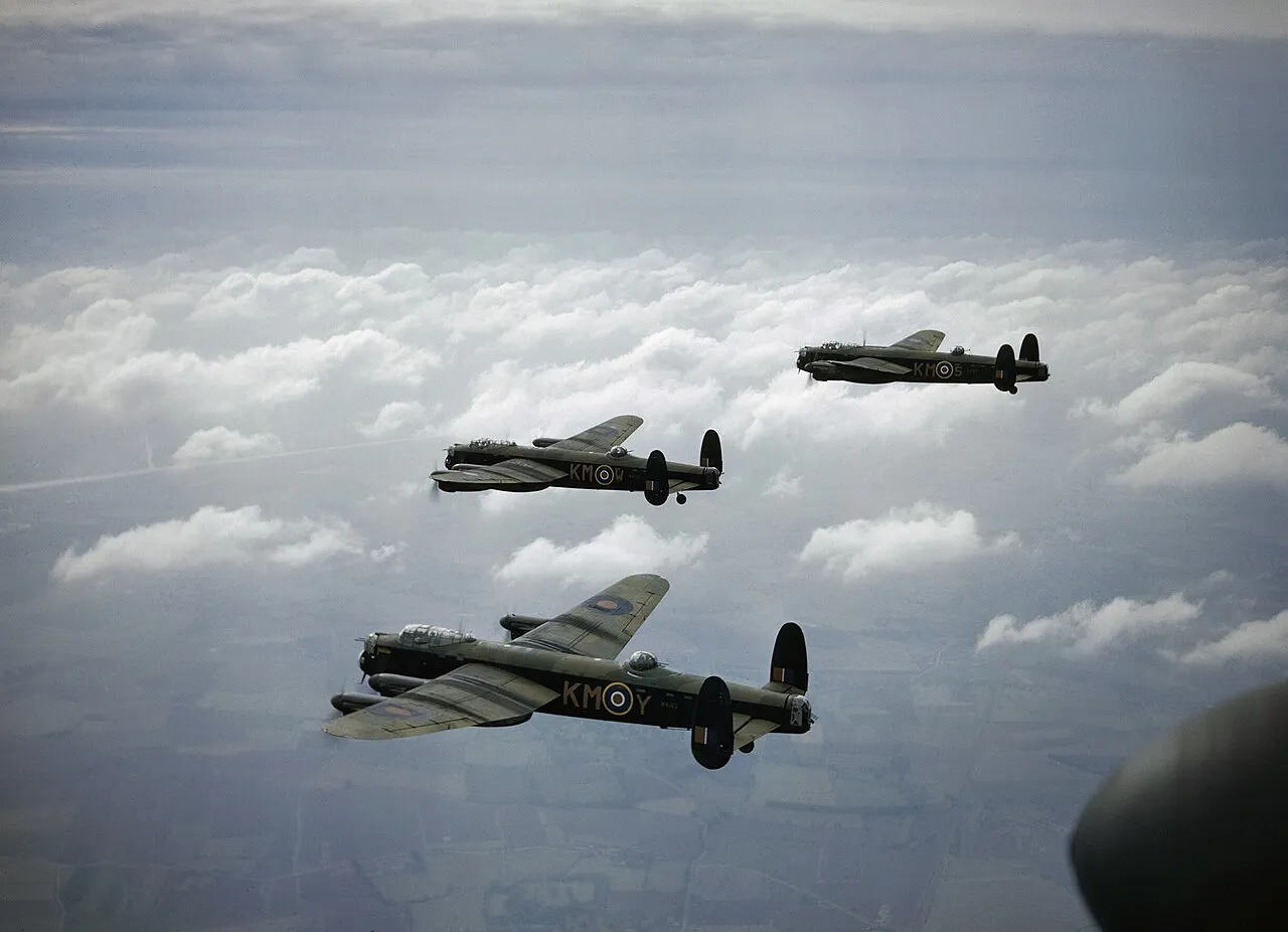 Three Avro Lancaster bombers of No. 44 Squadron RAF flying in formation above clouds in 1942.
