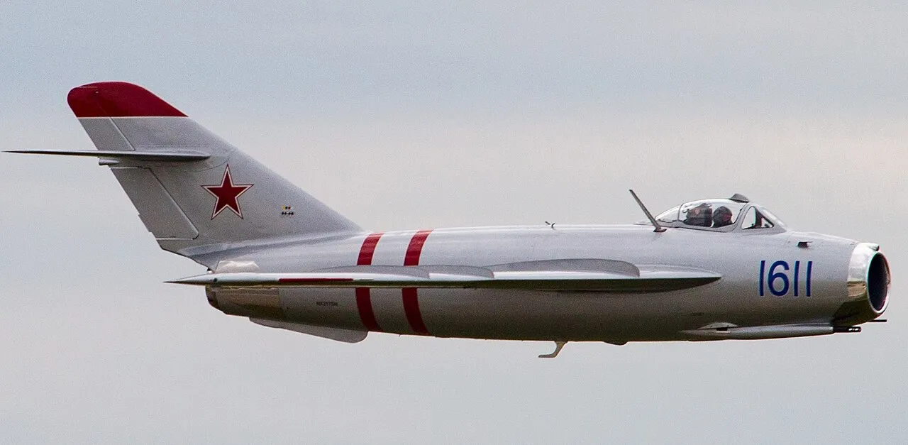 A preserved Mikoyan-Gurevich MiG-17 jet fighter on display, its swept wings and single afterburning jet exhaust visible.