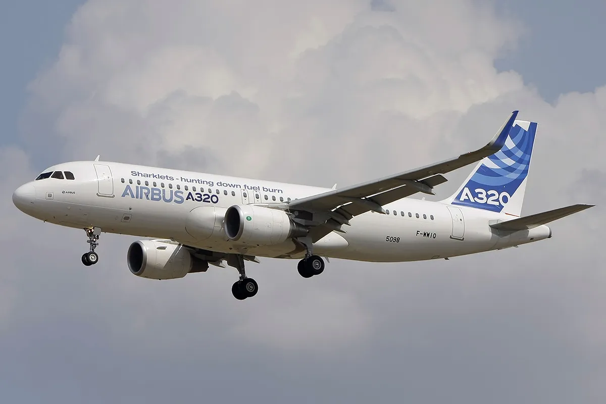 An Airbus A320-214 in Airbus house livery on approach with its landing gear down.