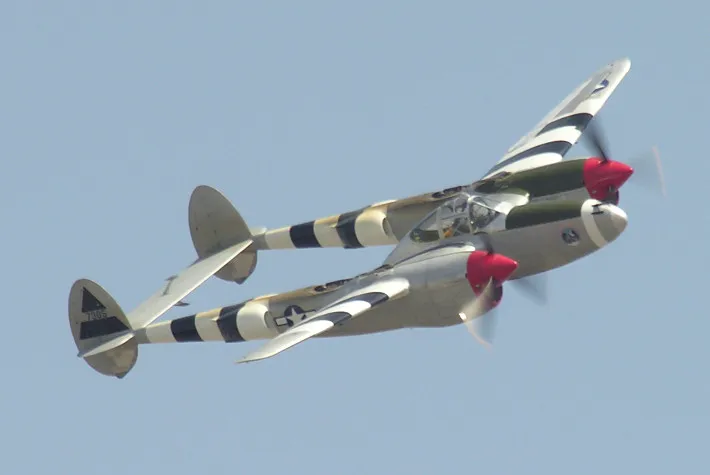 A twin-boom, twin-engined P-38J Lightning fighter parked on the ramp at Chino, California.