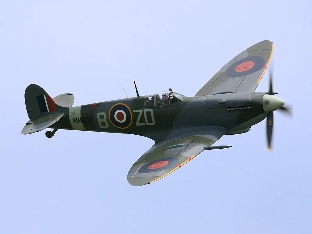 A Supermarine Spitfire fighter banking in flight at an air show.